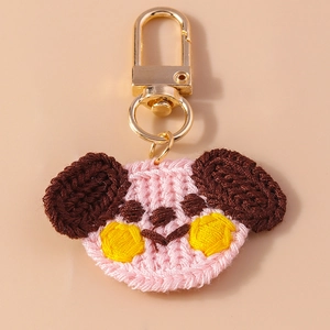 Detail of pink knitted bear keychain showing fine crochet textures and golden lobster clasp