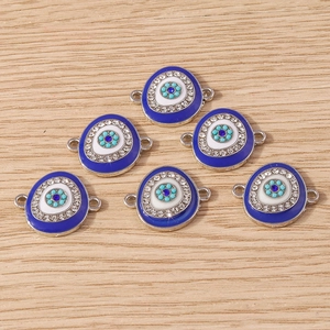 Macro detail of blue evil eye jewelry connectors with white crystal rhinestones for DIY