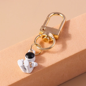 Detail of creative astronaut keychain with golden D-ring clasp and star-shaped emblem