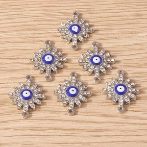Macro view of star-shaped evil eye connectors with rhinestones and double rings