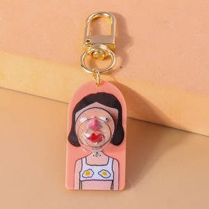 Close-up of cute cartoon girl keychain featuring pink acrylic base and golden metal clasp