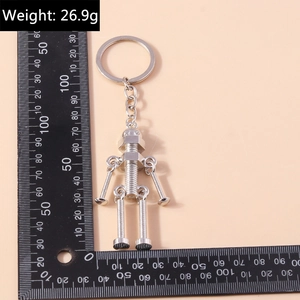 Detailed view of robot keychain made of metal bolts and nuts next to a measurement ruler