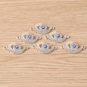 Macro view of six silver evil eye connectors with sparkling rhinestones on wood surface