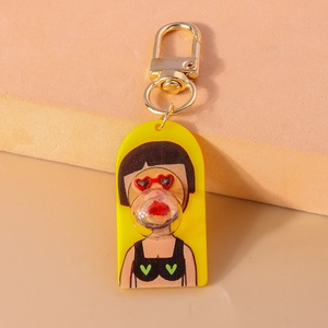 Detail of cartoon girl acrylic keychain with polka dot bikini and golden metal clasp