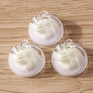 Close-up of translucent white resin candy pendants with spiral texture for DIY jewelry