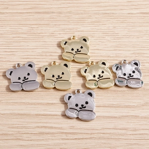 Détail macro de breloques ours dorées et argentées pour colliers et bracelets DIY
