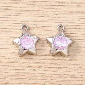Détail de deux pendentifs étoile argentés avec cristaux roses étincelants