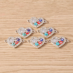 Macro view of silver heart connectors with evil eye charms and sparkling rhinestones
