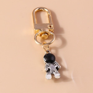 Detail of silver astronaut keychain with gold D-ring clasp and black enamel helmet star
