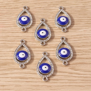 Macro detail of tear-drop evil eye pendants with silver rhinestones and double connectors