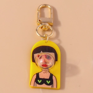 Detailed close-up of cartoon character keychain with gold lobster clasp and yellow acrylic base