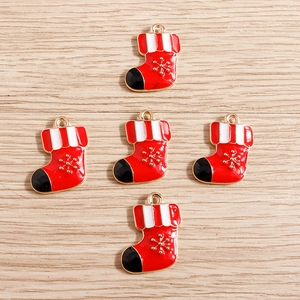 Detailed view of red Christmas stocking pendants with golden snowflake on wood background