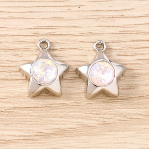 Gros plan de pendentifs étoile en argent avec strass irisés sur un fond en bois