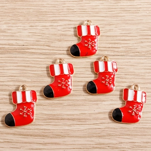 Detail of red enamel Christmas stocking charms with golden snowflakes and hooks