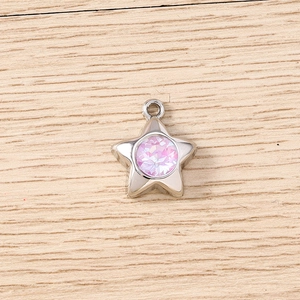 Détail d'un pendentif étoile argenté avec un strass rose violet facetté sur bois