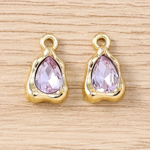Detailed macro view of two lilac teardrop crystal pendants with wavy gold metal frames
