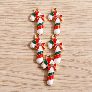 Macro detail of Christmas candy cane pendants with red bows and enamel stripes for DIY jewelry