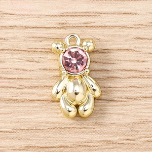 Detail of a 3D golden bear pendant with a faceted pink gemstone and secure top loop