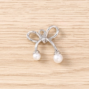 Vue détaillée d'un pendentif nœud argenté avec perles blanches pour bijoux faits main