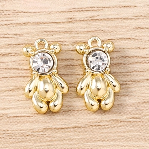 Macro detail of gold bear-shaped alloy pendants with sparkling zircon stone for DIY jewelry