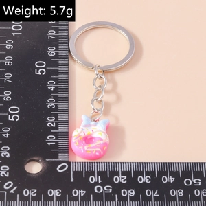 Detailed size view of a pink donut keychain with light blue bow and sprinkles