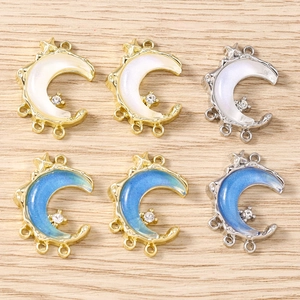 Detailed view of multi-loop crescent moon charms with shell inlay and crystal accents