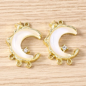 Detail of crescent moon jewelry charms with white pearl inlay and tiny zircon accents