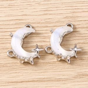 Detail of silver crescent moon charms with pearlescent inlay and triple hanging loops
