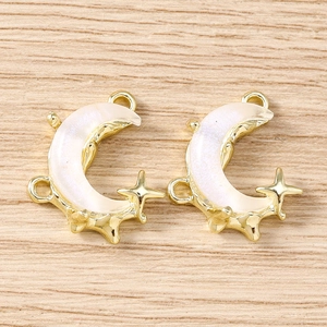 Detailed macro view of moon and star charms with gold frame and pearlescent inlay