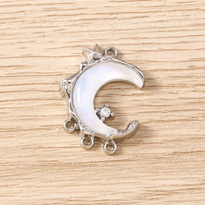 Macro detail of crescent moon pendant with mother of pearl shell inlay and cubic zirconia