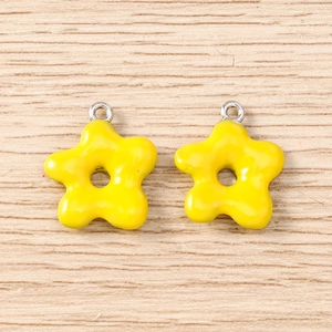 Detail showing two yellow flower charms with glossy finish for DIY jewelry crafting