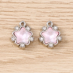 Vue macro de pendentifs en étoile avec cristaux roses et pierres blanches scintillantes