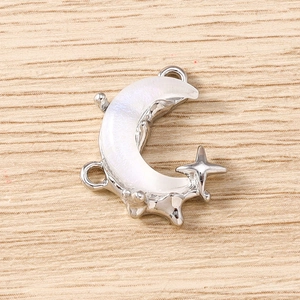 Detailed close-up of crescent moon and star charms with pearl inlay for DIY jewelry