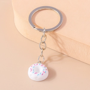 Detail showing a white donut keychain with pink and blue sprinkles on a metal ring