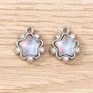 Vue macro de deux pendentifs étoiles en argent avec pierre d'opale et zircons