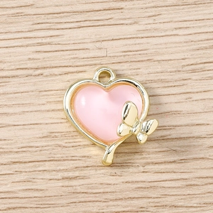 Vue détaillée du pendentif cœur doré avec résine rose et décoration de nœud élégant