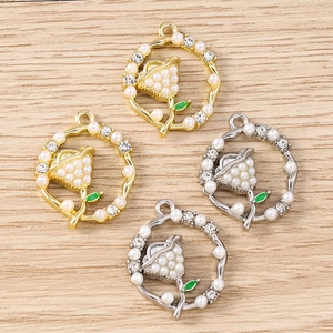 Macro detail of lily of the valley pendants with pearls and rhinestones on wood