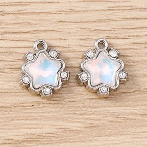 Détail macro de pendentifs étoile en argent avec opales irisées et strass brillants
