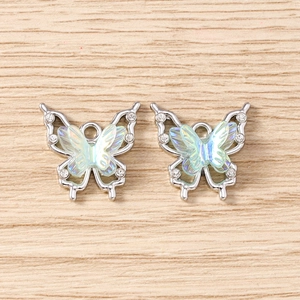 Detailed close-up of rhinestone flower butterfly pendants for jewelry making on wood background
