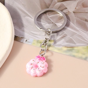 Macro shot of a pink donut keychain with resin bow and colorful sprinkles on a metal ring