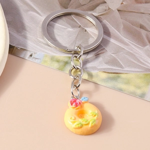 Detail of creative donut keychain with pink resin rose and silver metal ring
