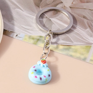 Detail of light blue donut keychain with strawberry topping and silver metal ring