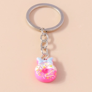 Close-up of a pink doughnut keychain with colorful sprinkles and a blue bow ornament