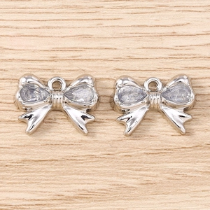 Dettaglio macro di ciondoli a fiocco argento con zirconi per creazioni di gioielli fai-da-te