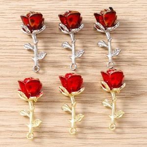 Detailed view of red enamel rose flower charms with gold and silver metal stems for DIY jewelry