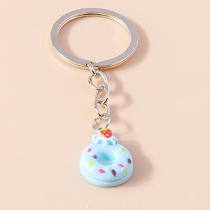Detail of creative blue donut keychain with sprinkles and a tiny strawberry charm