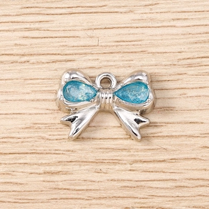Macro del ciondolo a fiocco in lega argento con cristalli azzurri e anello di aggancio