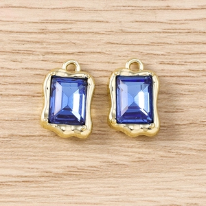 Detalle de colgantes rectangulares de cristal azul con base dorada de textura fina