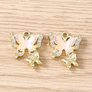 Detail of pink iridescent butterfly charms with gold metal frame and white rhinestones