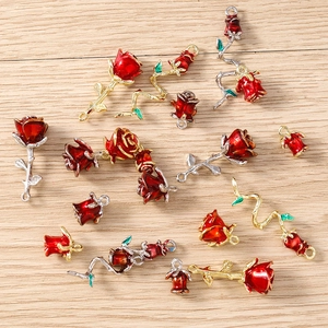 Detailed view of red enamel rose pendants with gold and silver plated metal alloy finish